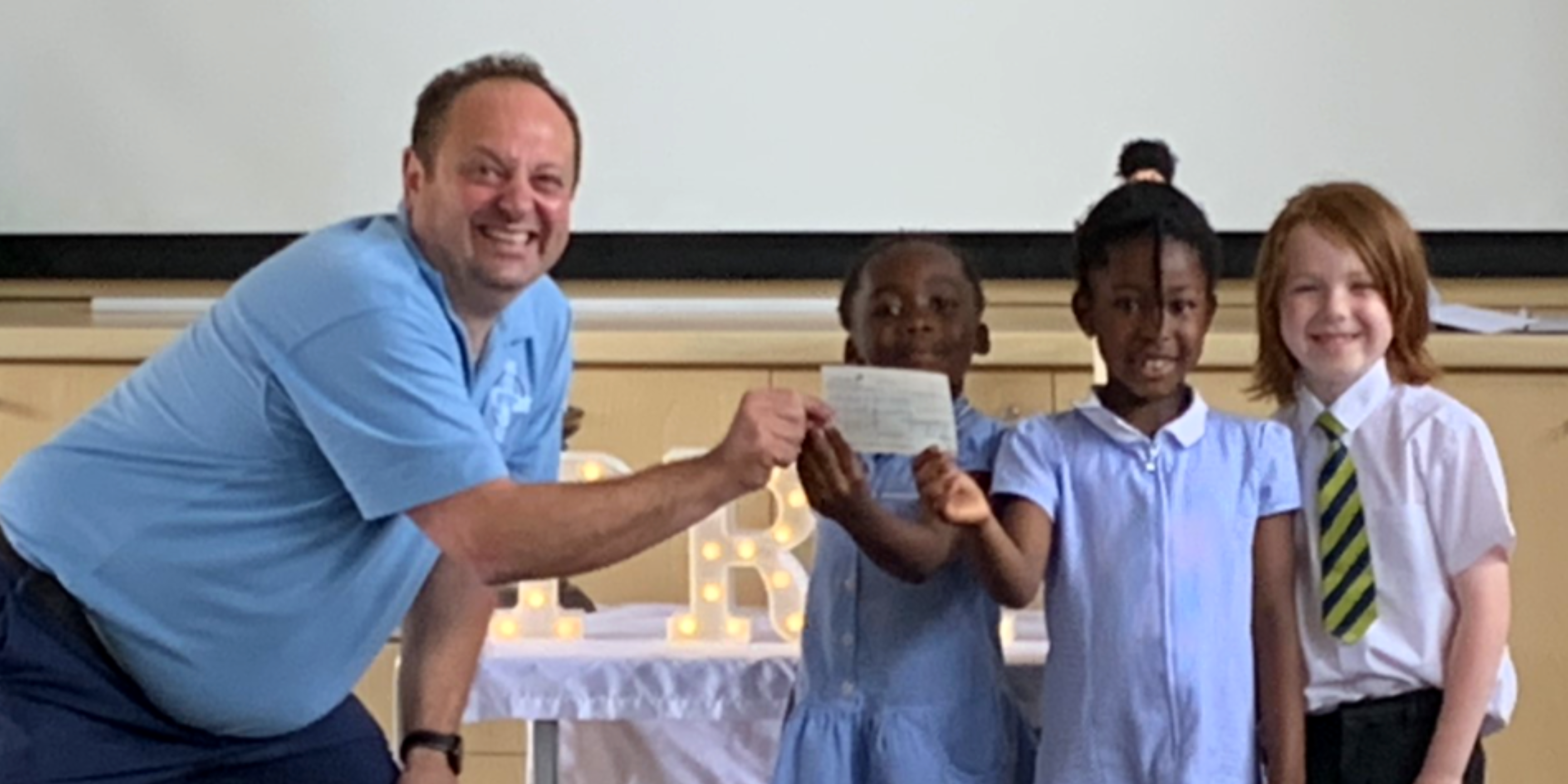 Centre manager with primary school children in uniform