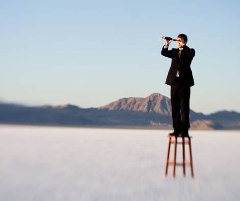 man standing on chair looking through telescope