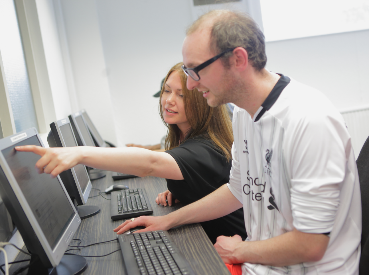 Two people looking at a desktop screen