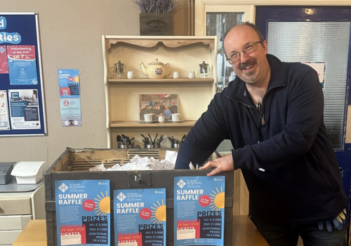 Image of man picking raffle ticket numbers out of a box