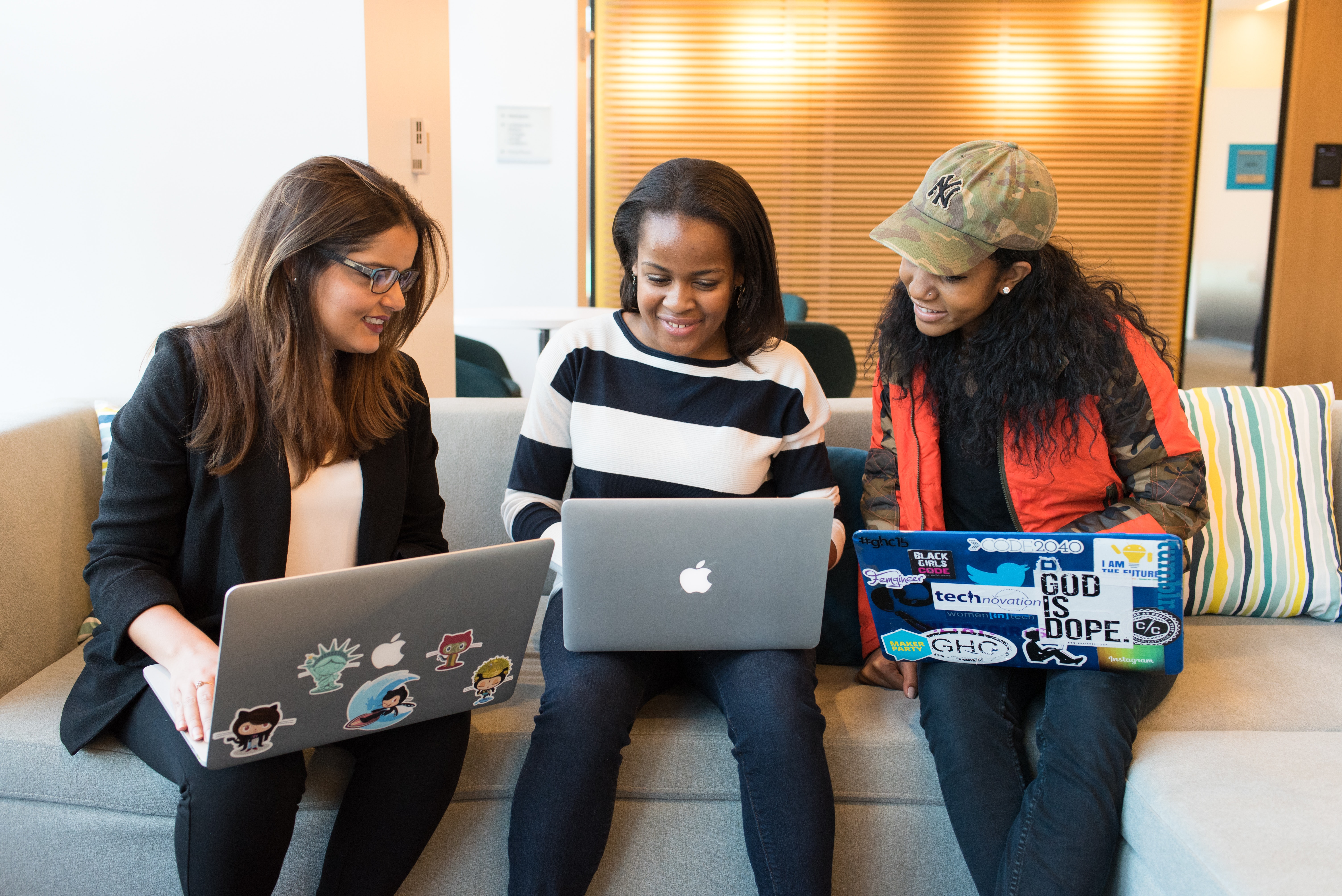 three women in front of a laptop